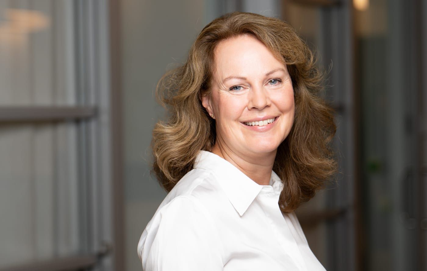 Portrait of a smiling Aleris colleague in a white blouse