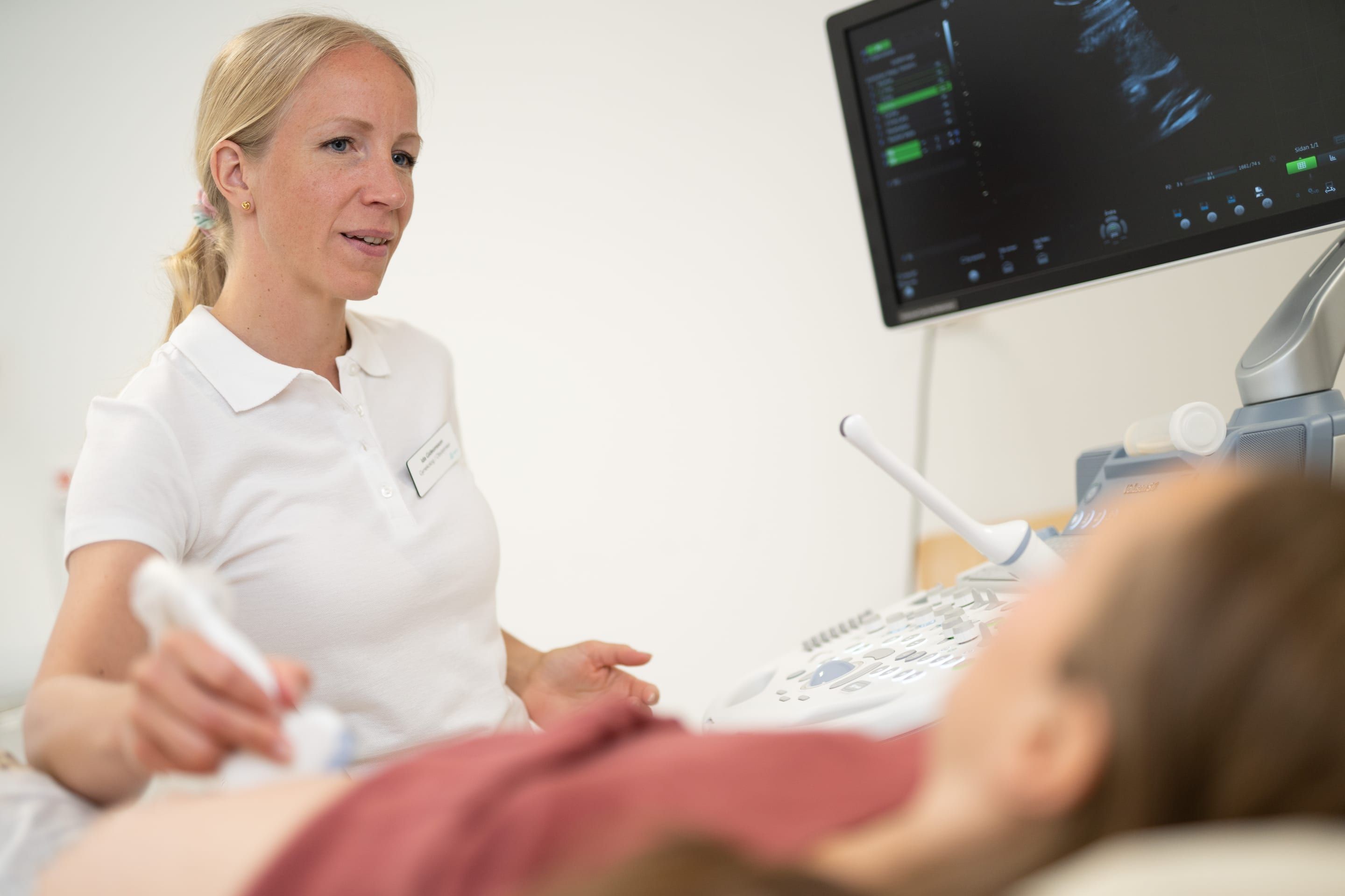 A sonographer talks with a patient during an ultrasound examination